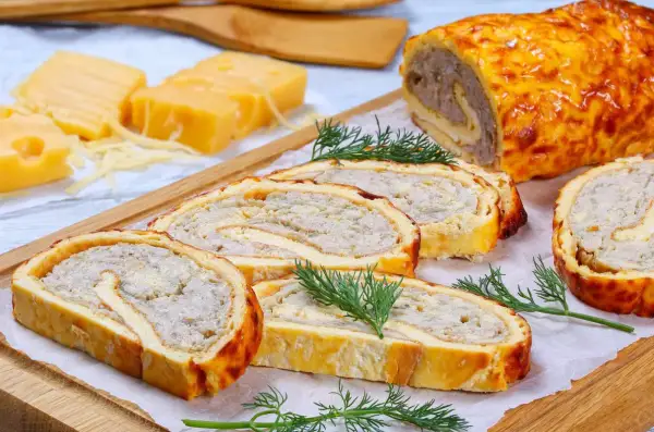 Pyszna rolada serowa z kurczakiem, pokrojona w plastry, z dodatkiem sera i koperku.